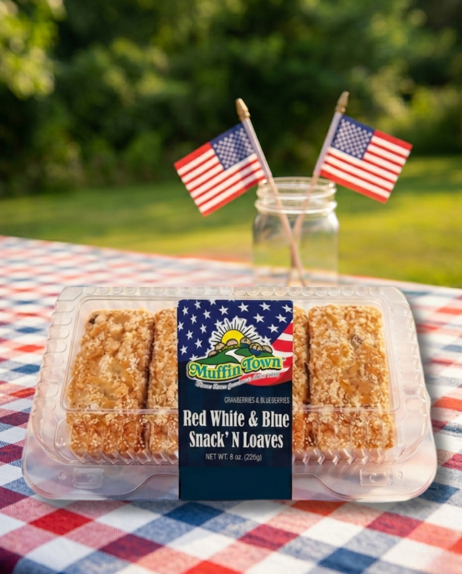 Muffin Town snack loaves in a clear container with American flags on a checkered tablecloth outdoors.